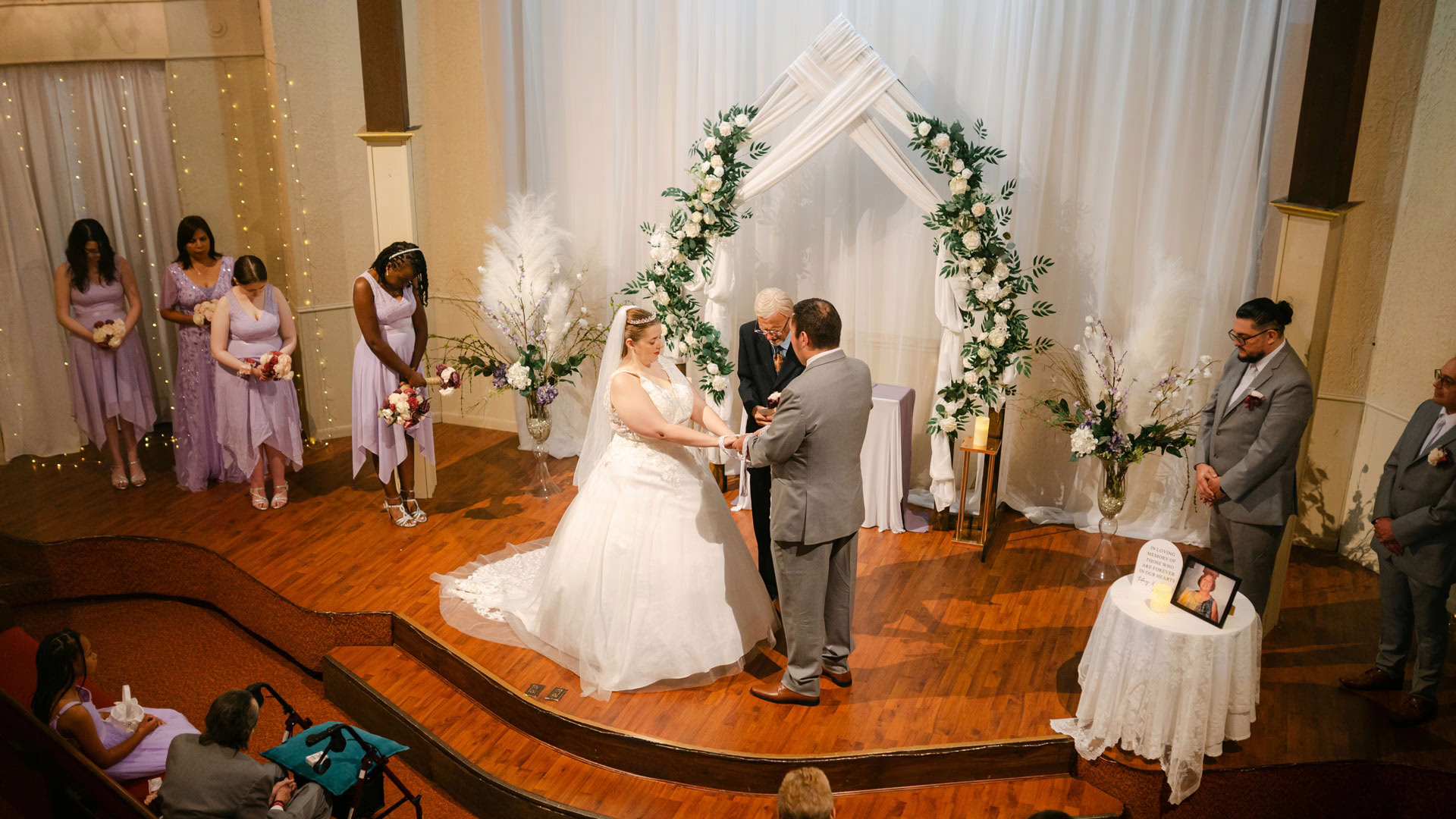 A bride and groom exchange vows during a wedding ceremony inside a beautifully decorated church.