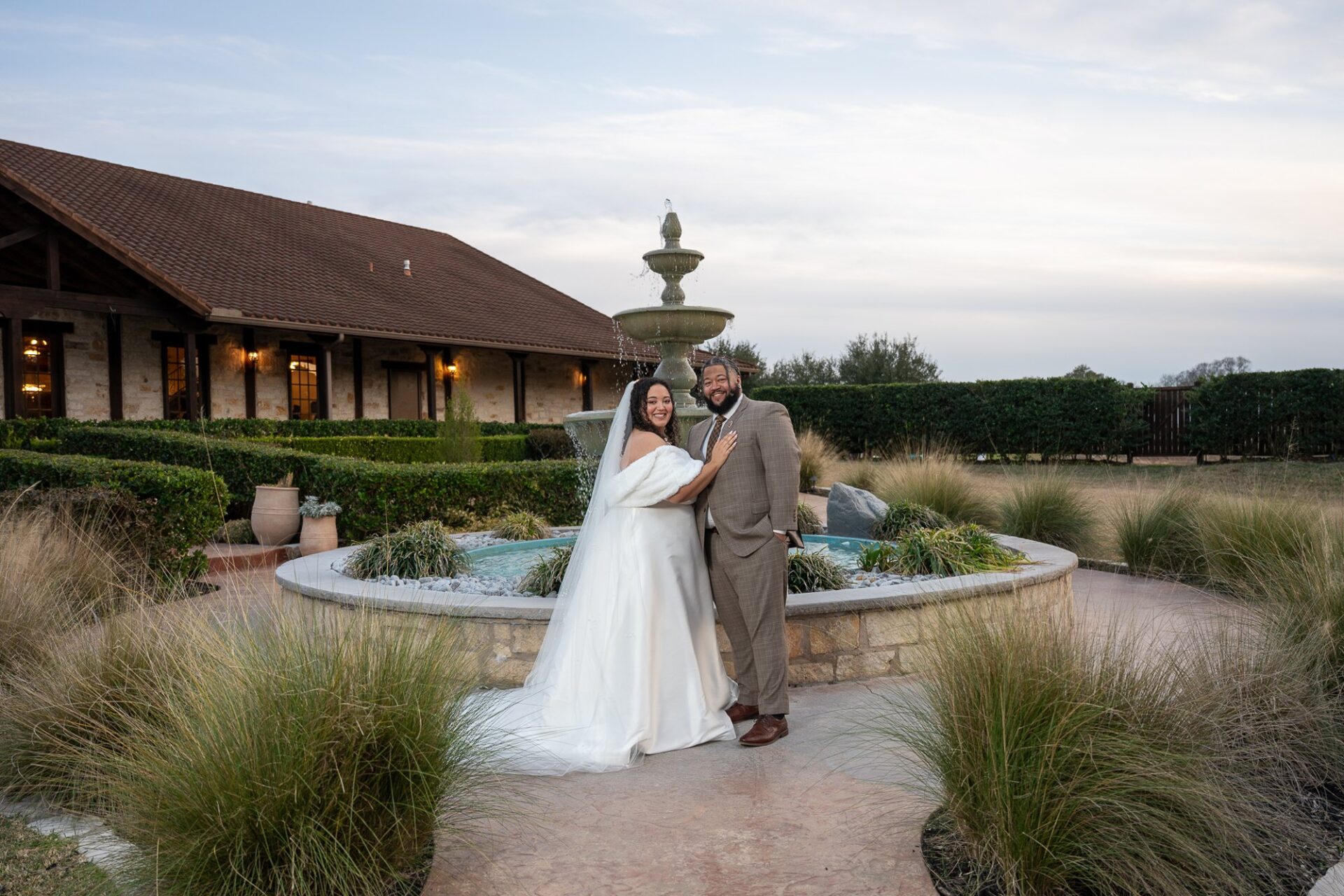 Thomas and Macee embracing beside the fountain at Villa Tuscana at The Springs in Katy, Texas