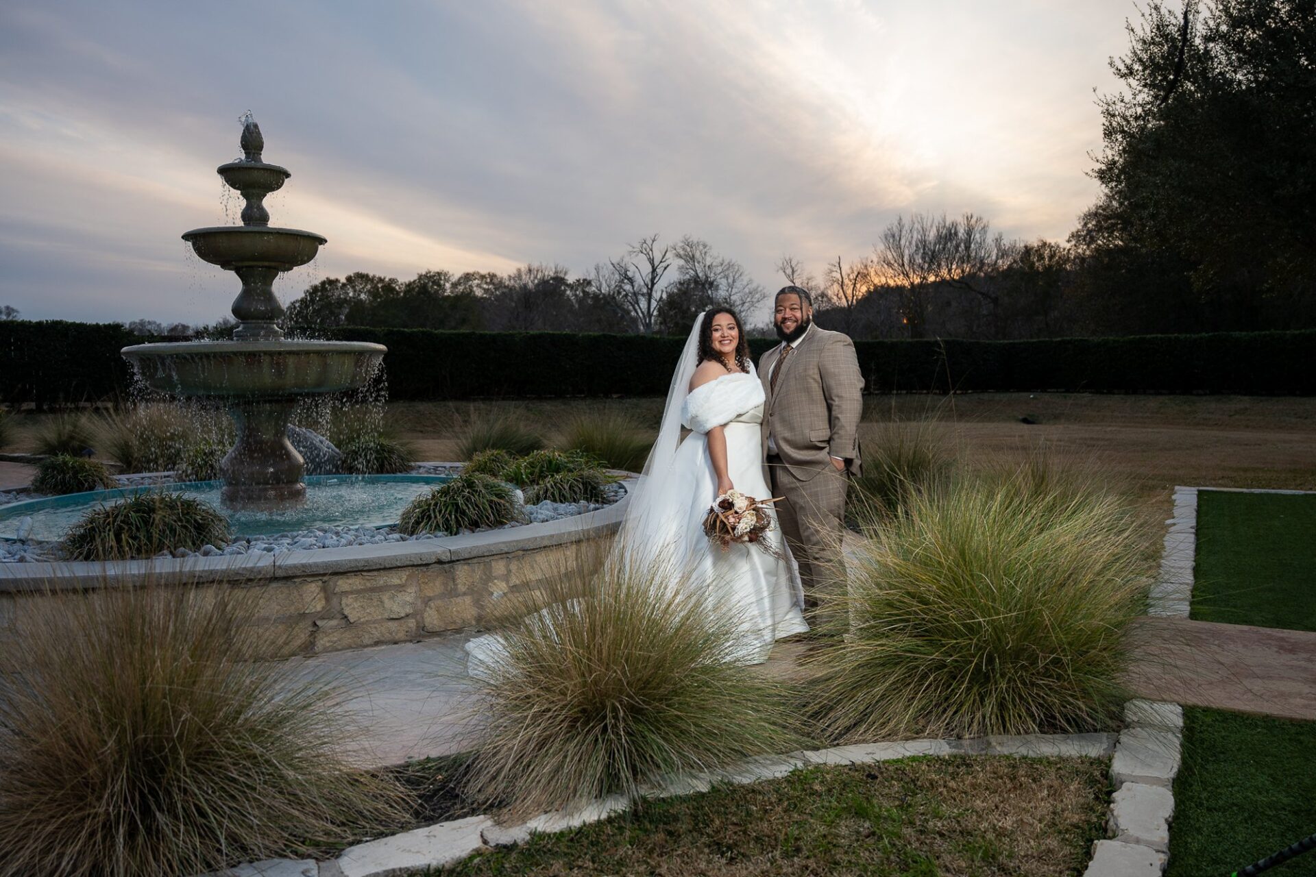 Thomas and Macee beside the fountain at dusk