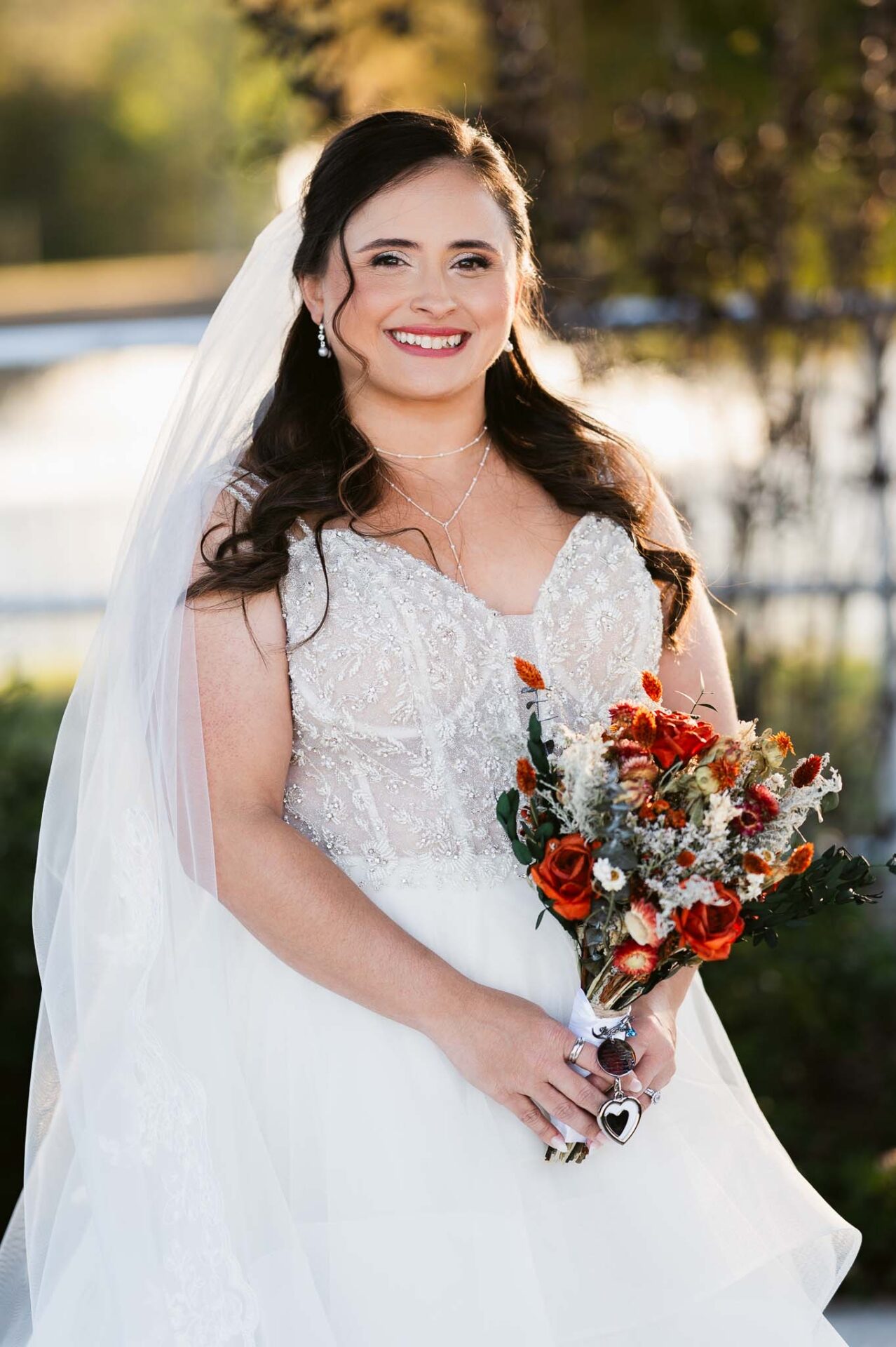 Close portrait of Andreea holding her autumn-colored wedding bouquet.