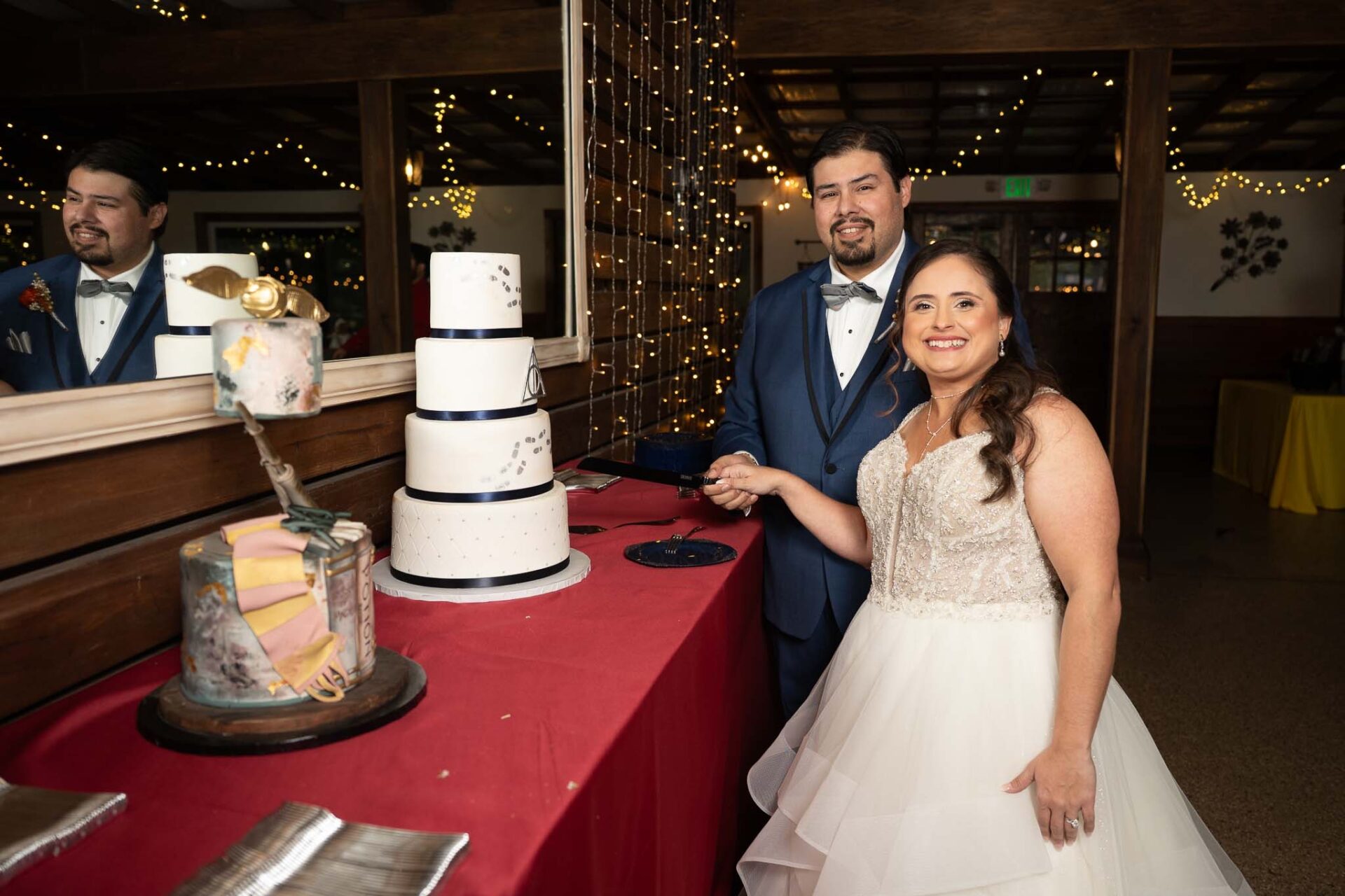 Andreea and Ram cut their wedding cake in the reception room.