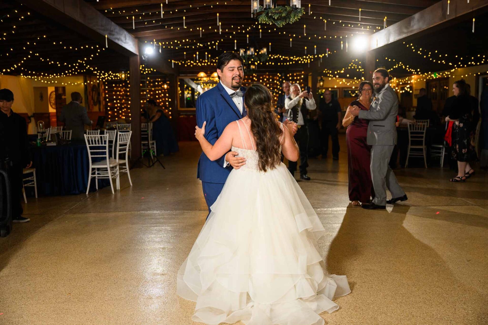 Andreea and Ram dance beneath the reception hall’s warm string lights.