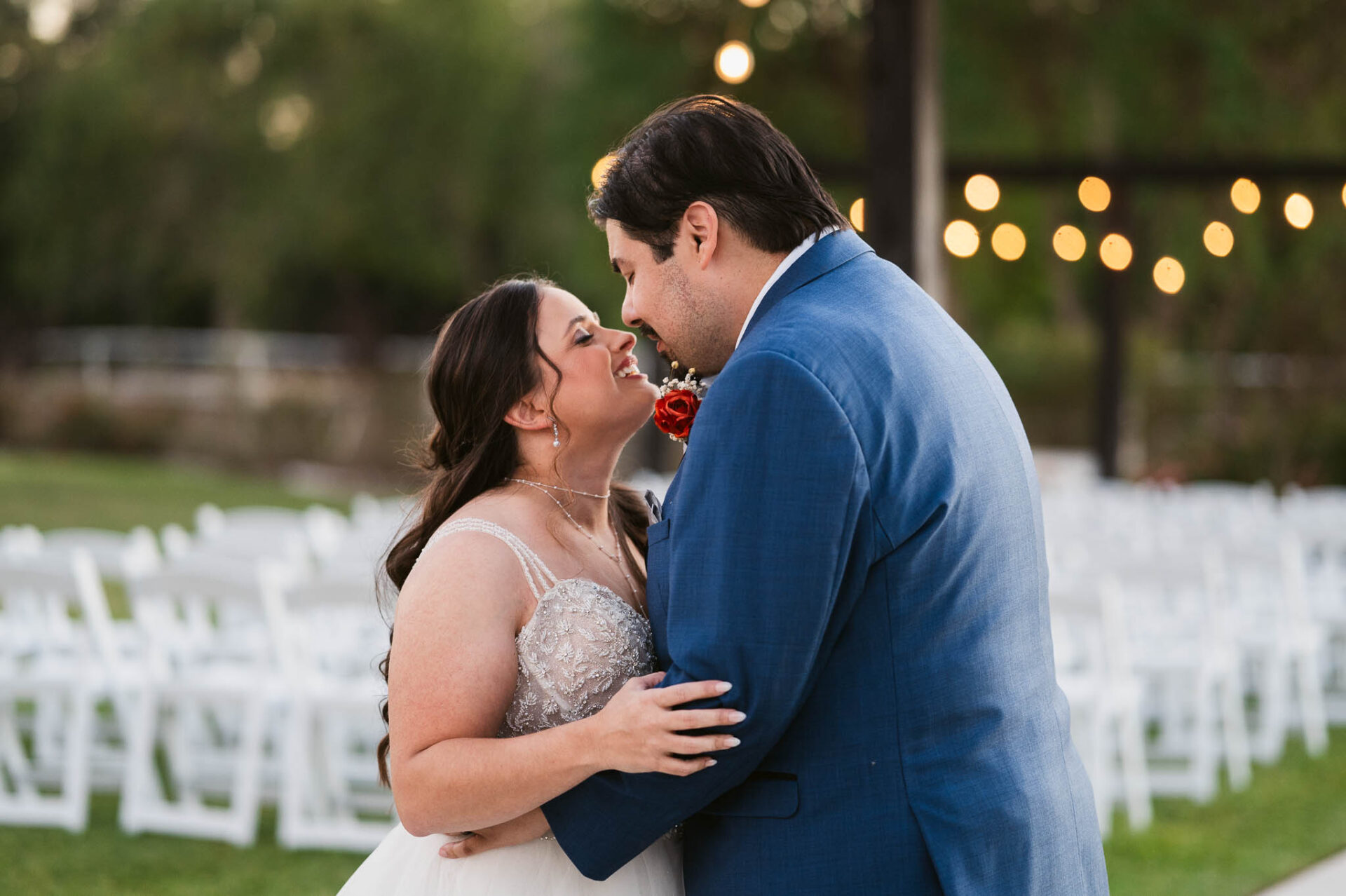 Andreea and Ram share a kiss during their reception beneath warm string lights.