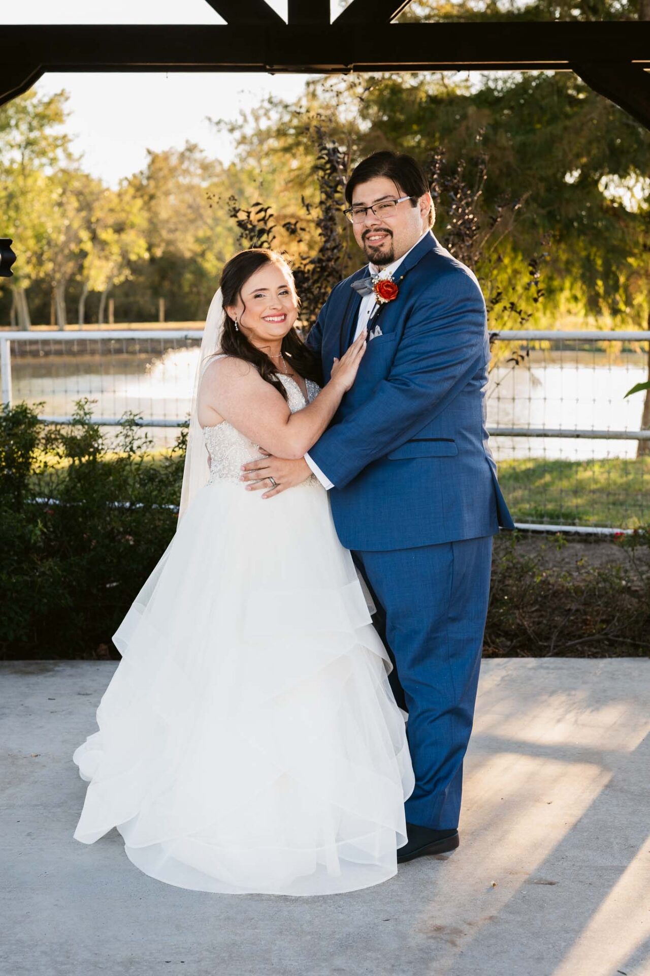 Andreea and Ram share a relaxed portrait beside the pond at Circle of Seven Ranch.