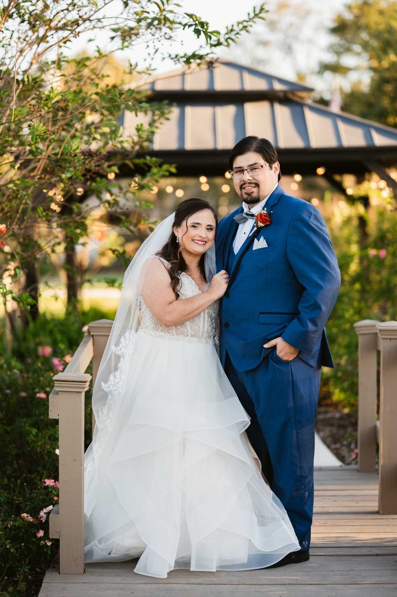 Andreea and Ram pose together along a landscaped ranch footbridge.