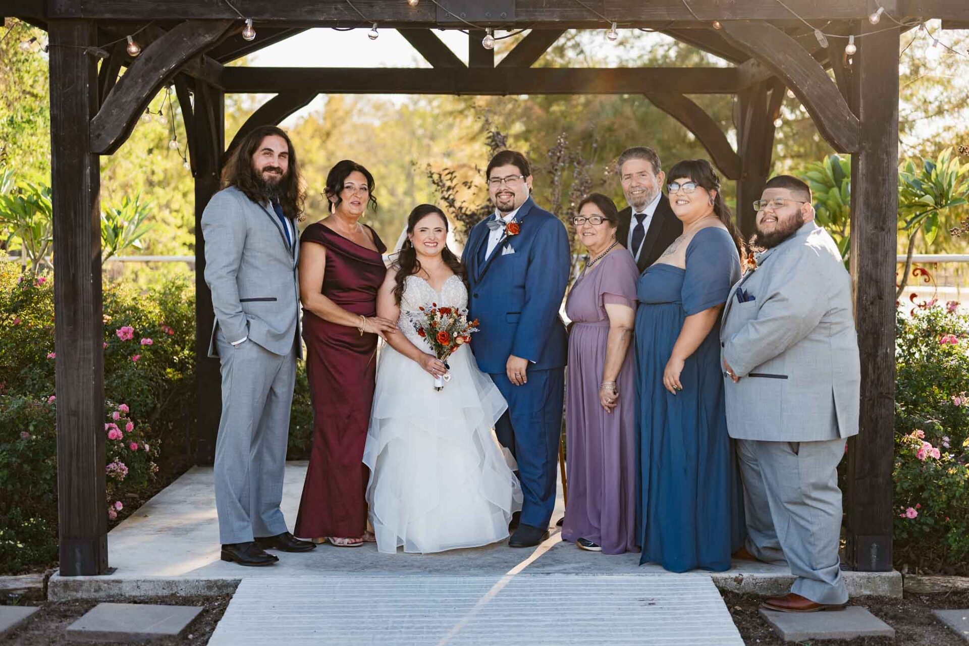 Andreea and Ram gather with family for a wedding portrait beneath the gazebo.