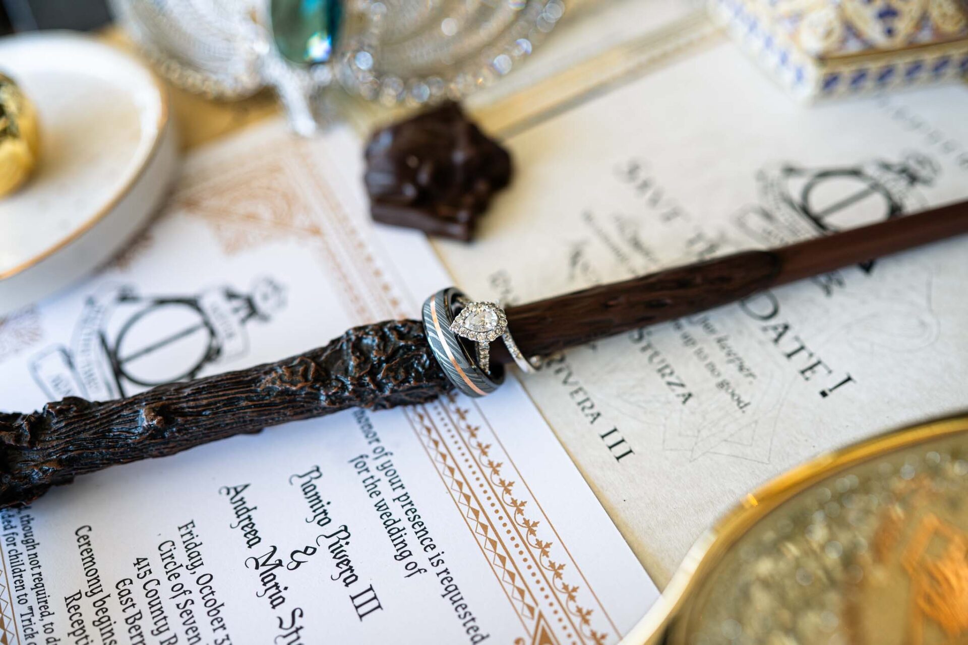 Andreea and Ram’s wedding rings arranged on a wooden wand above their invitation.