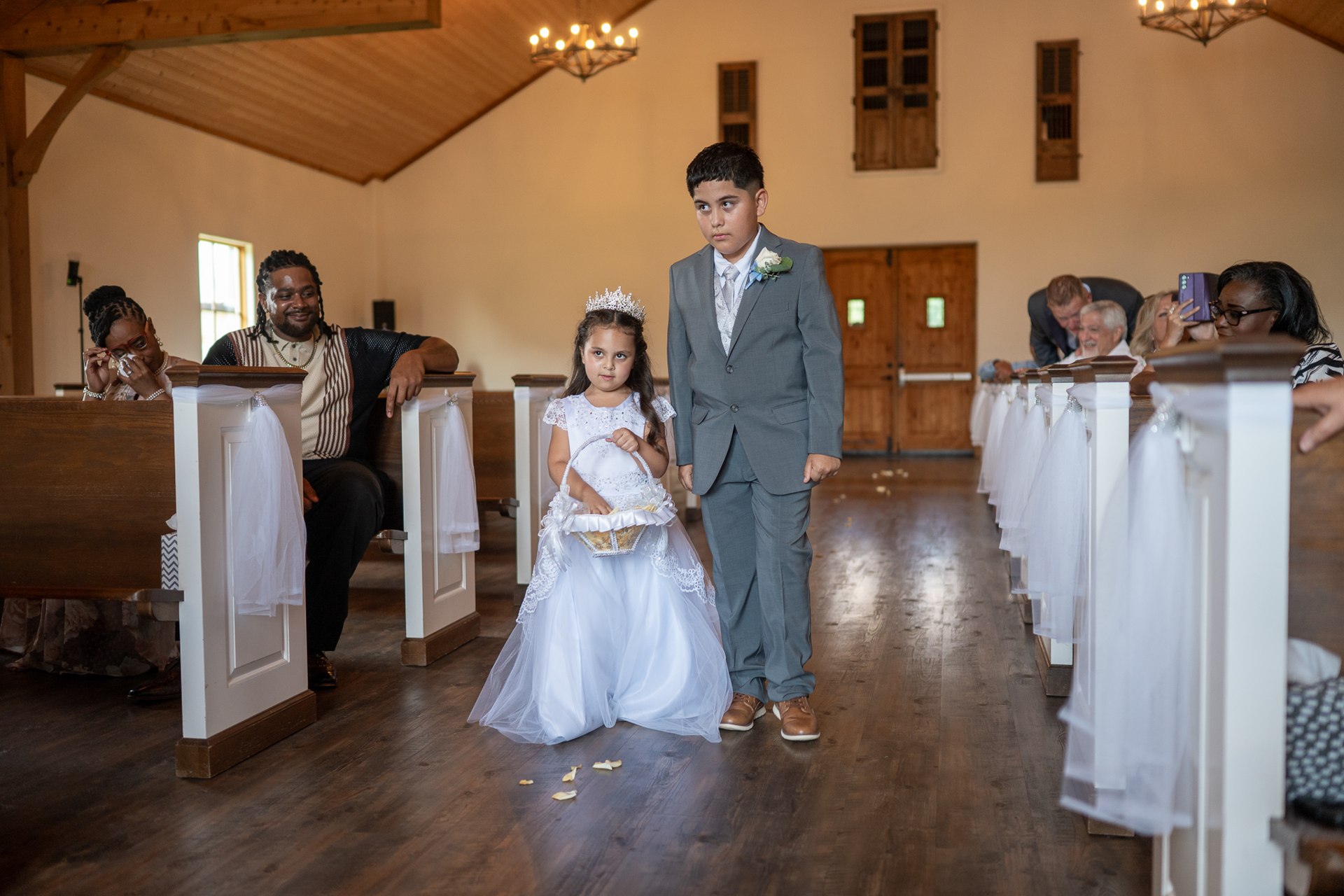 Two children walking down the chapel aisle