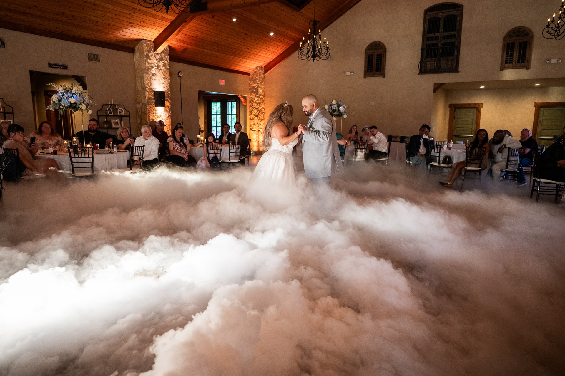 Elijah and Marissa dancing amid low fog in the reception ballroom