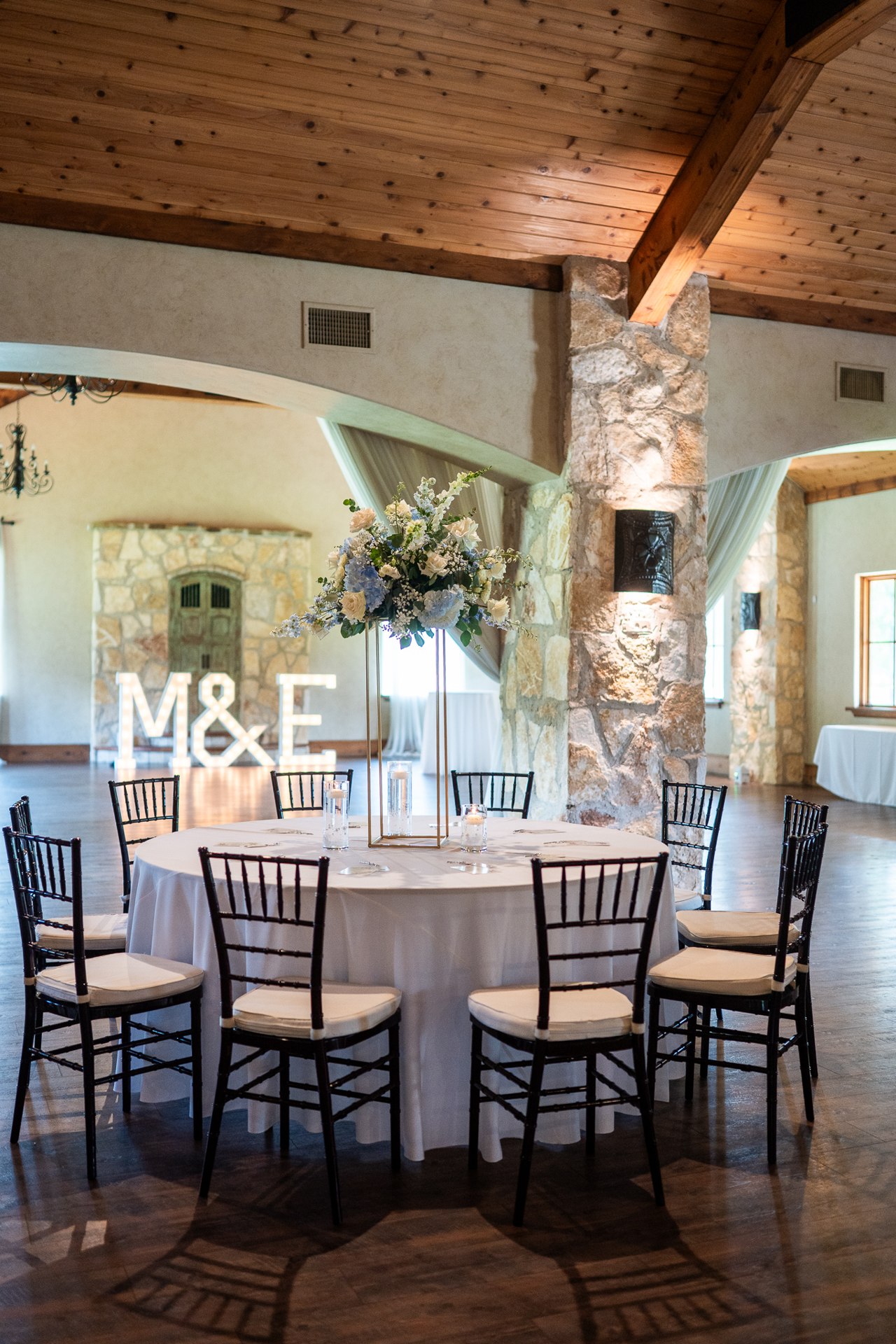 Reception table with illuminated M and E initials and floral decorations