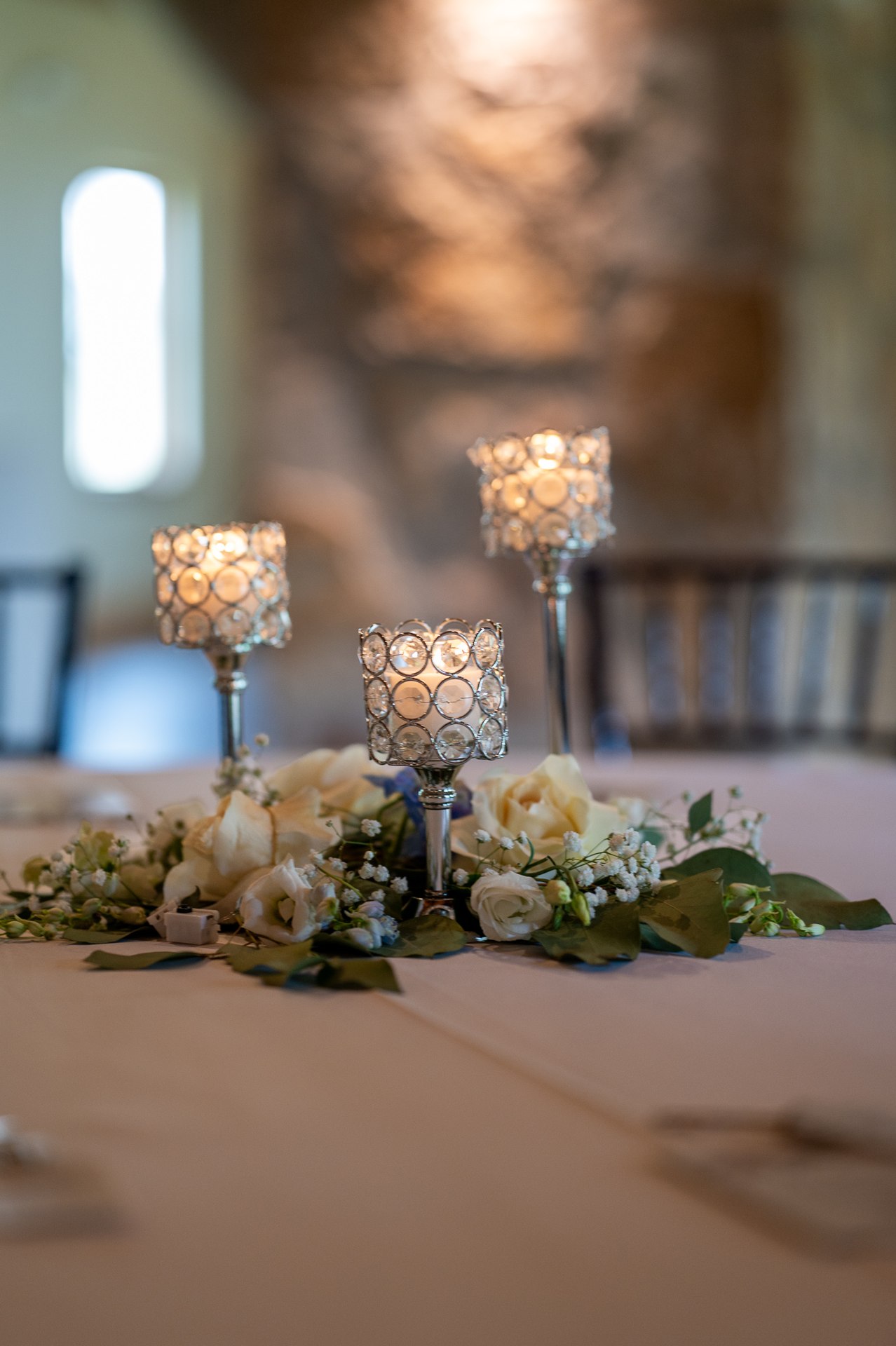 White and pale blue flowers with candleholders on a reception table