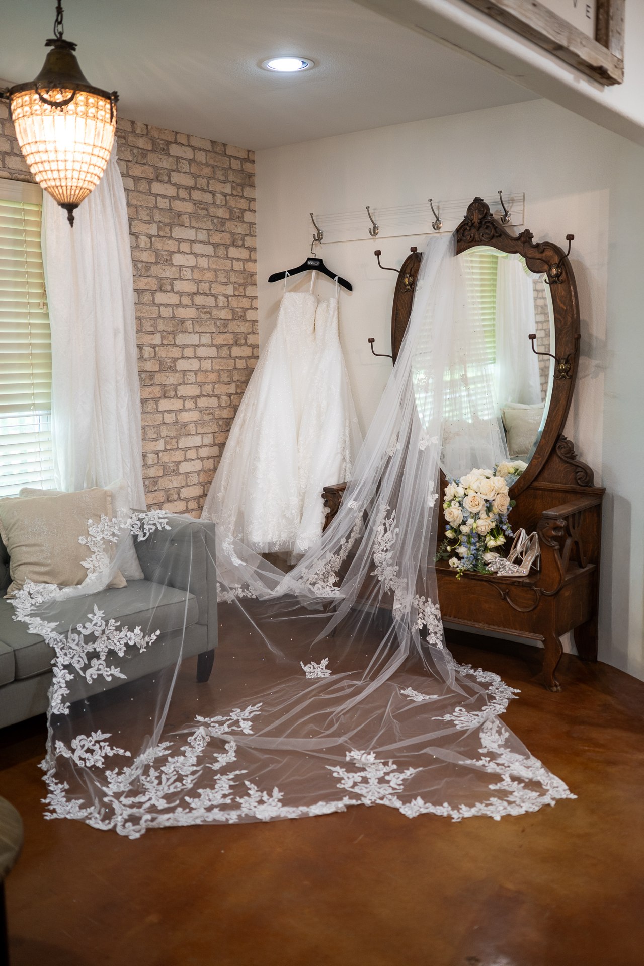 Marissa’s wedding dress and long lace train displayed beside a mirror