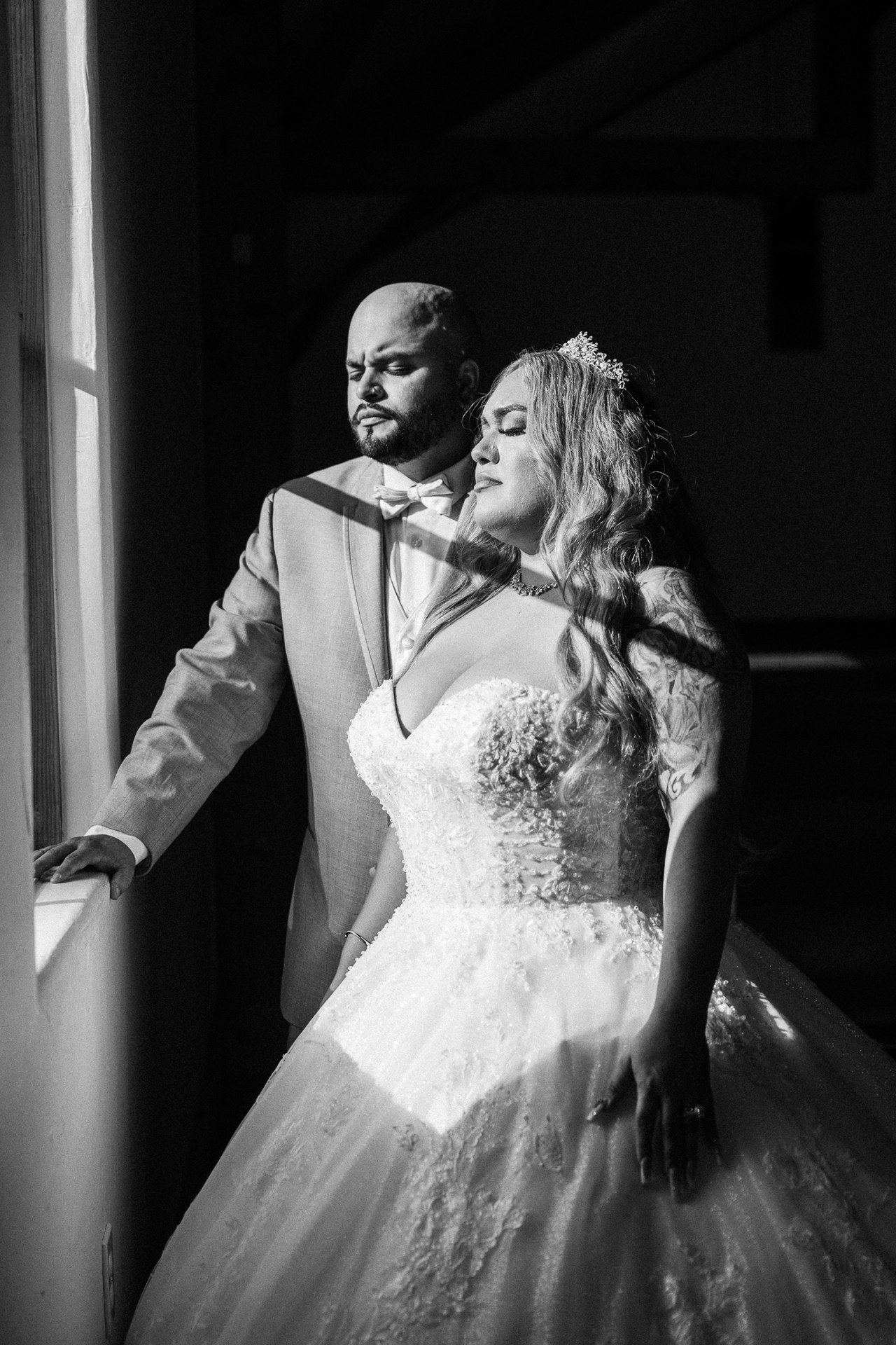 Black-and-white portrait of Elijah and Marissa in window light