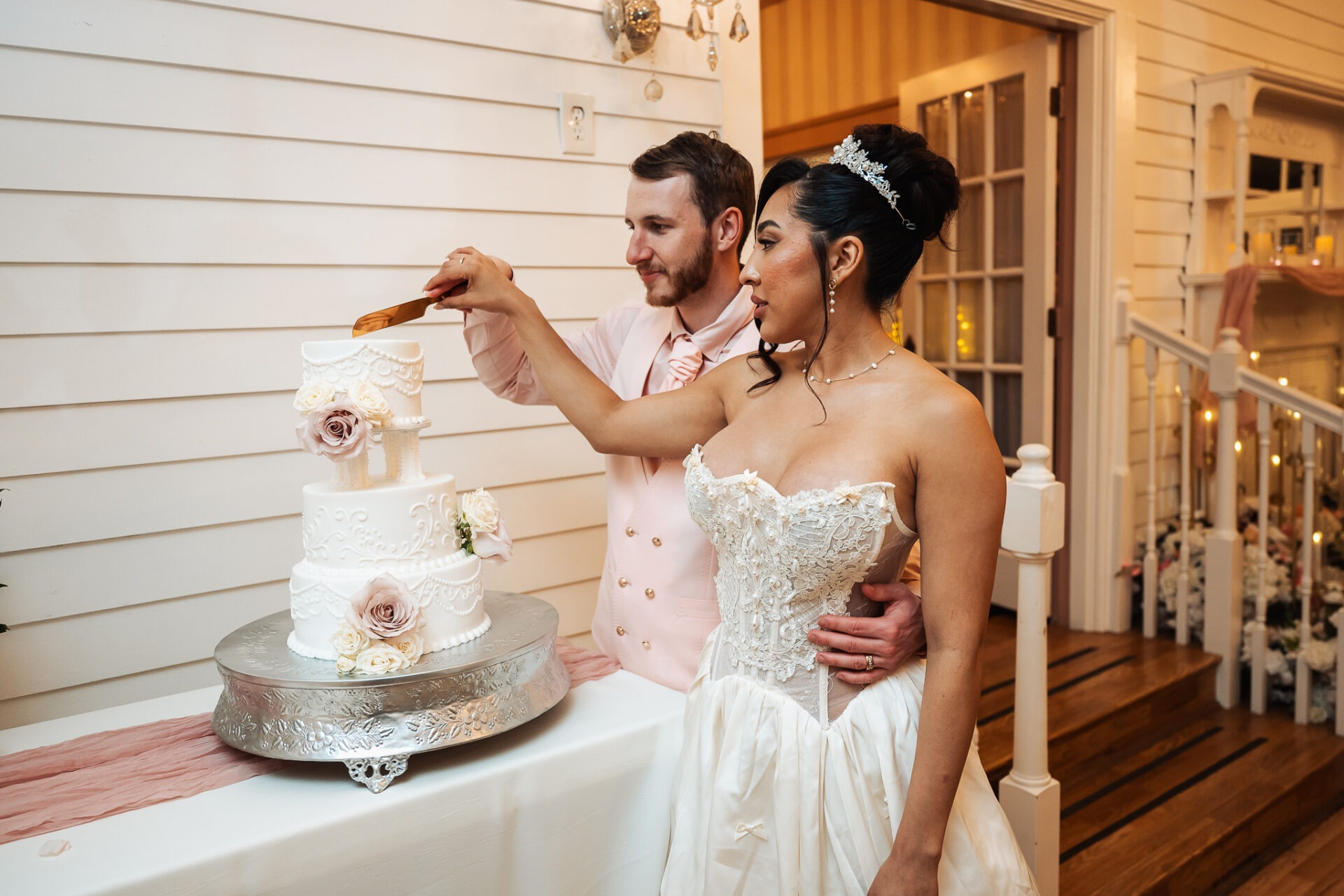 Grisel and Zachary cutting their ivory wedding cake together