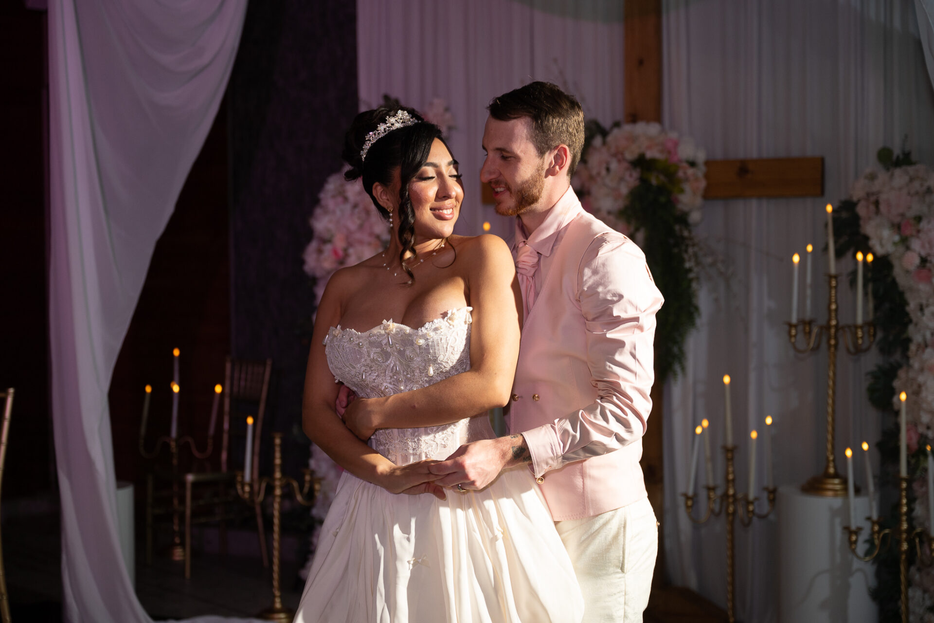 Grisel and Zachary posing together in evening light beside gold candelabra