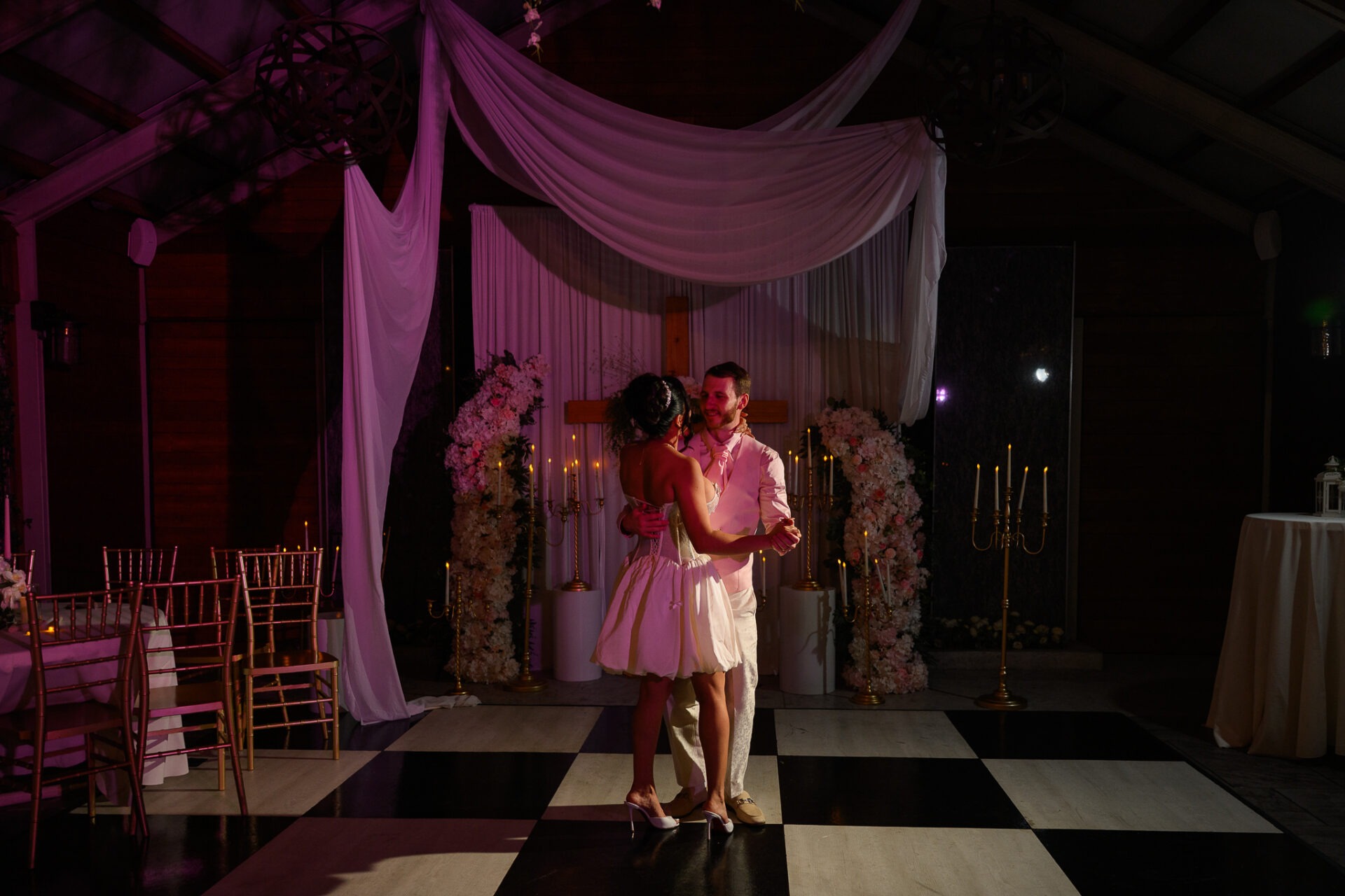 Grisel and Zachary sharing a final dance beneath white draping