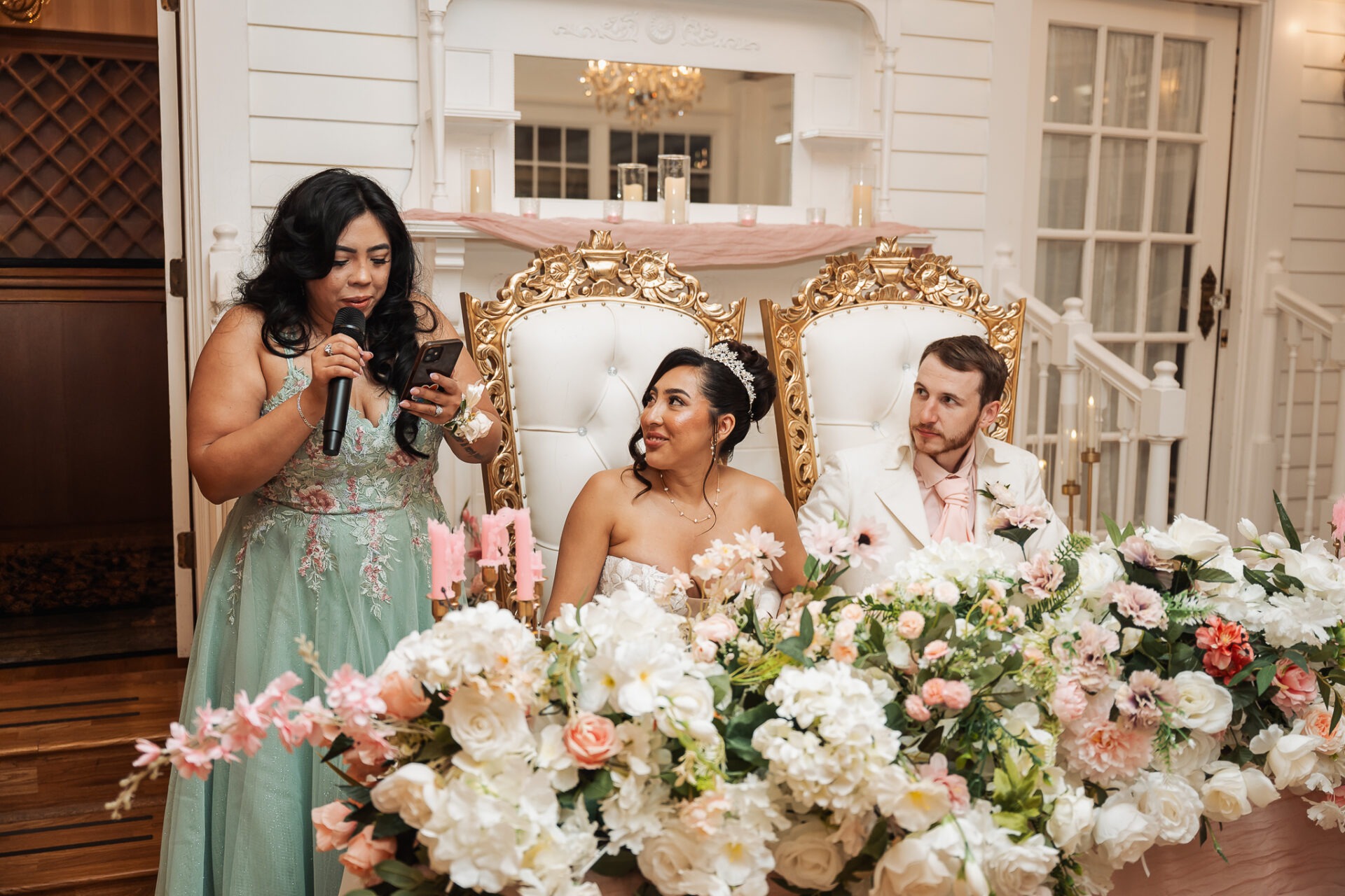 A guest giving a toast as Grisel and Zachary listen at their sweetheart table