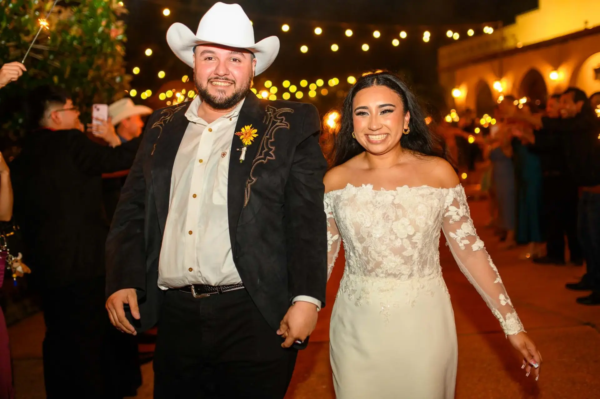 Vanessa and Reymundo smiling beneath outdoor string lights at night