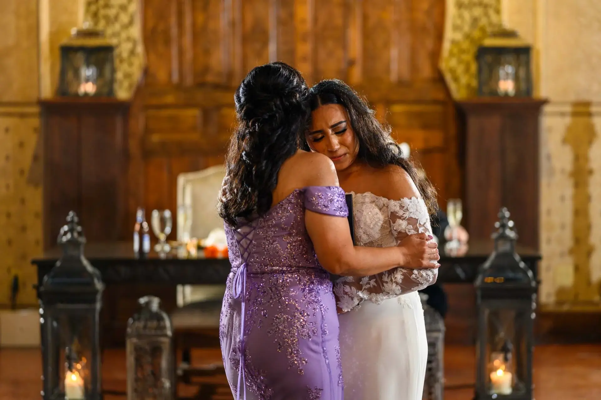 Vanessa embracing a woman in a lavender dress during the reception