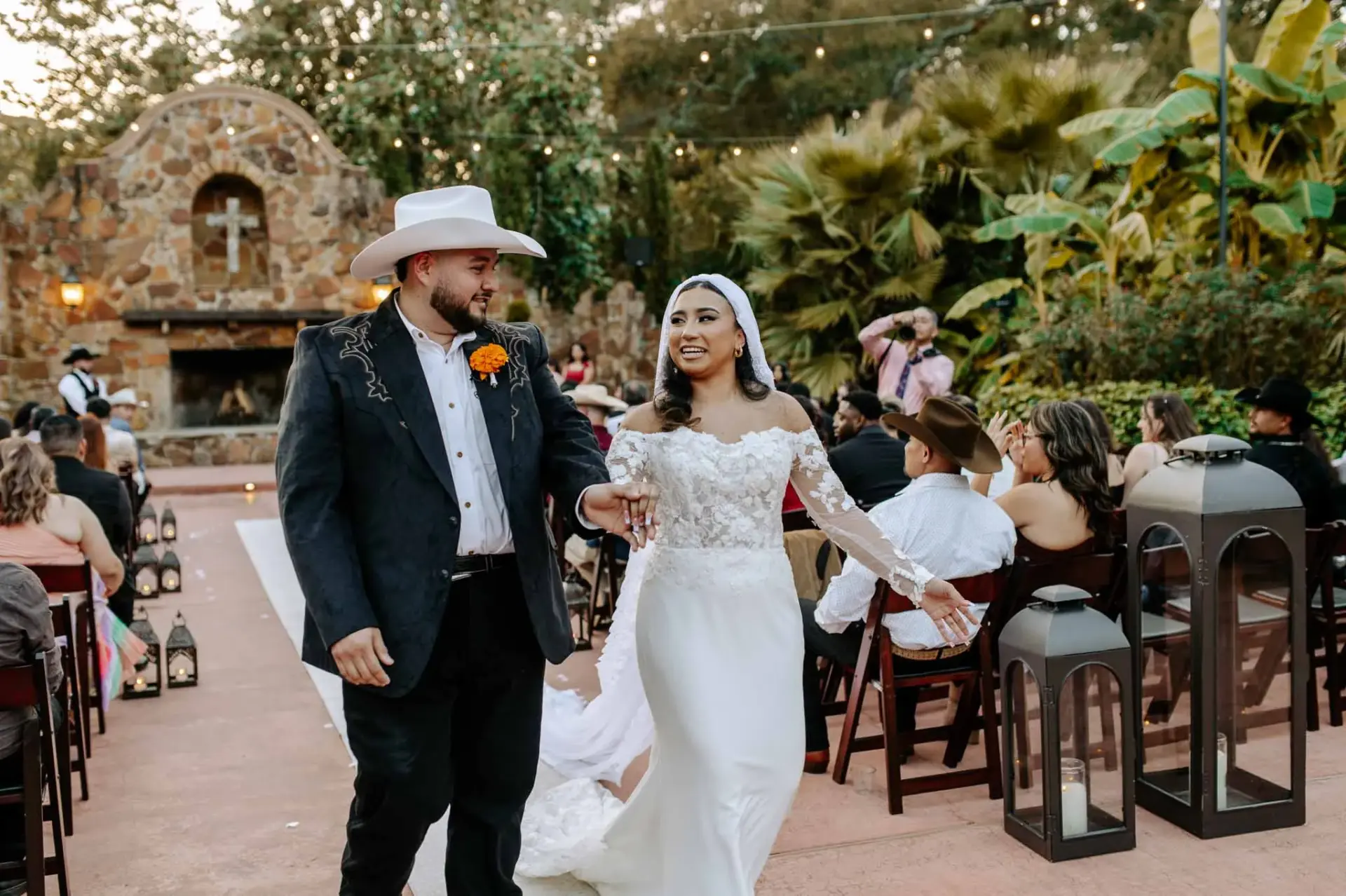 Vanessa and Reymundo smiling as they walk together past their guests