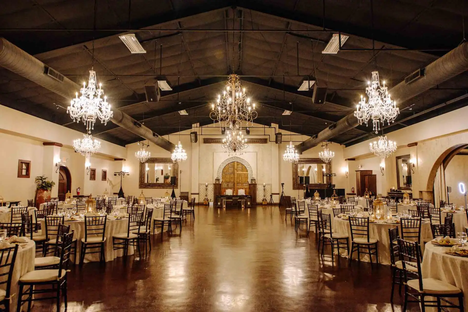 Wide view of the reception room with tables and chandeliers