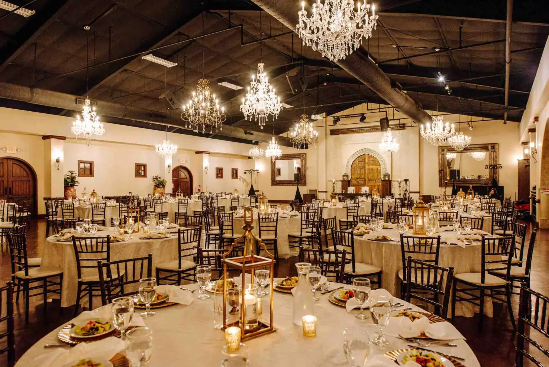 Reception table and chandeliers beneath the dark wood ceiling