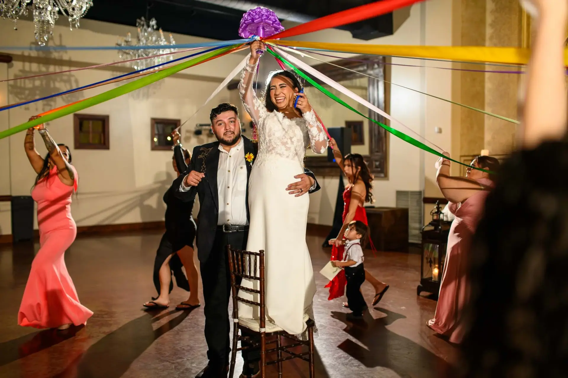 Vanessa raising a bouquet with colorful ribbons during the celebration