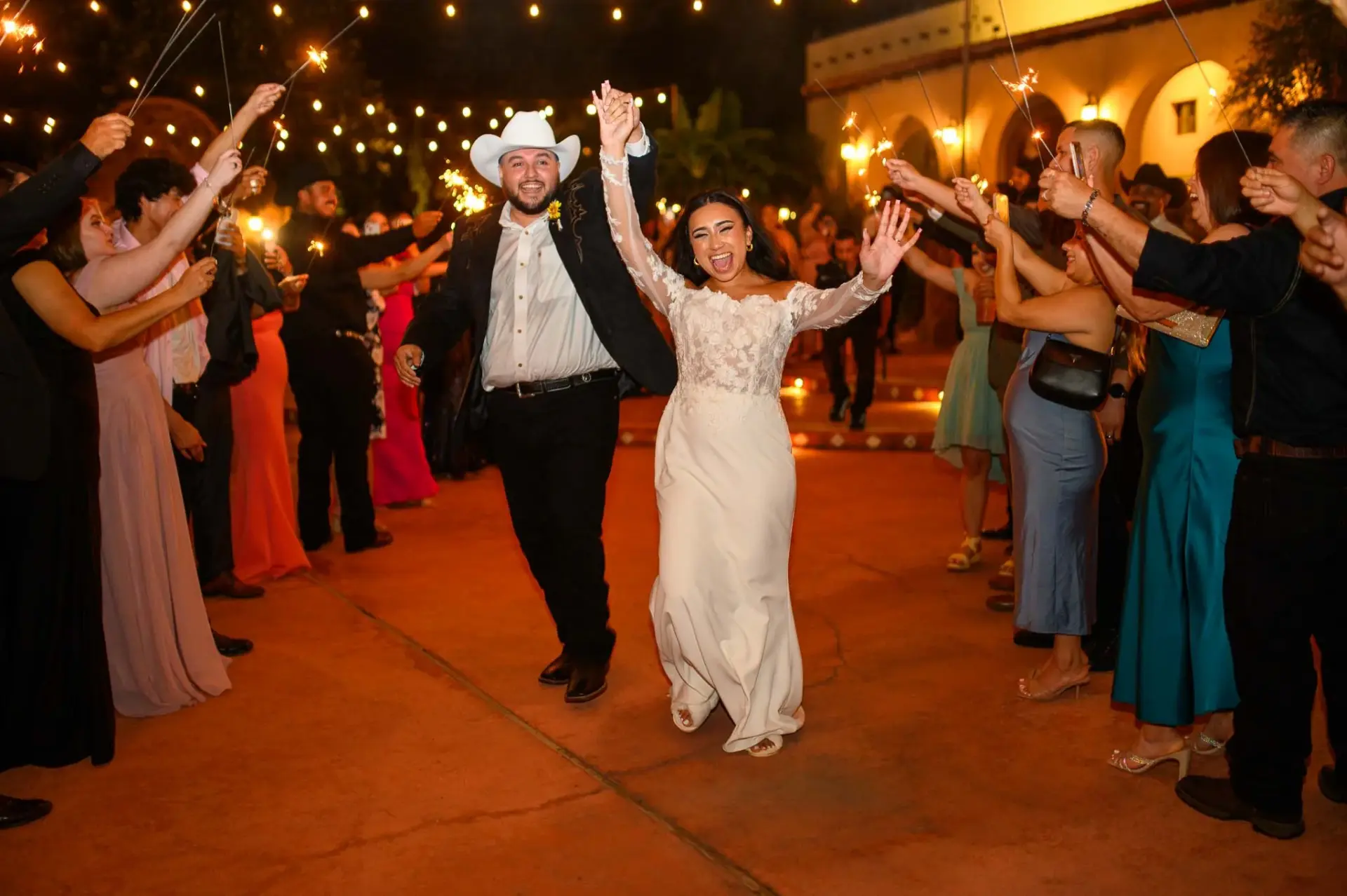 Vanessa and Reymundo walking between guests holding sparklers