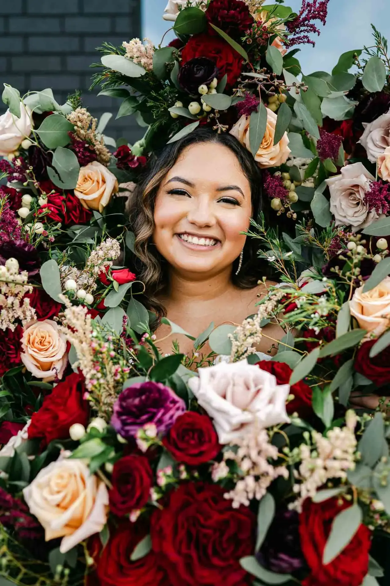 Lauren holding a bouquet of red and white flowers