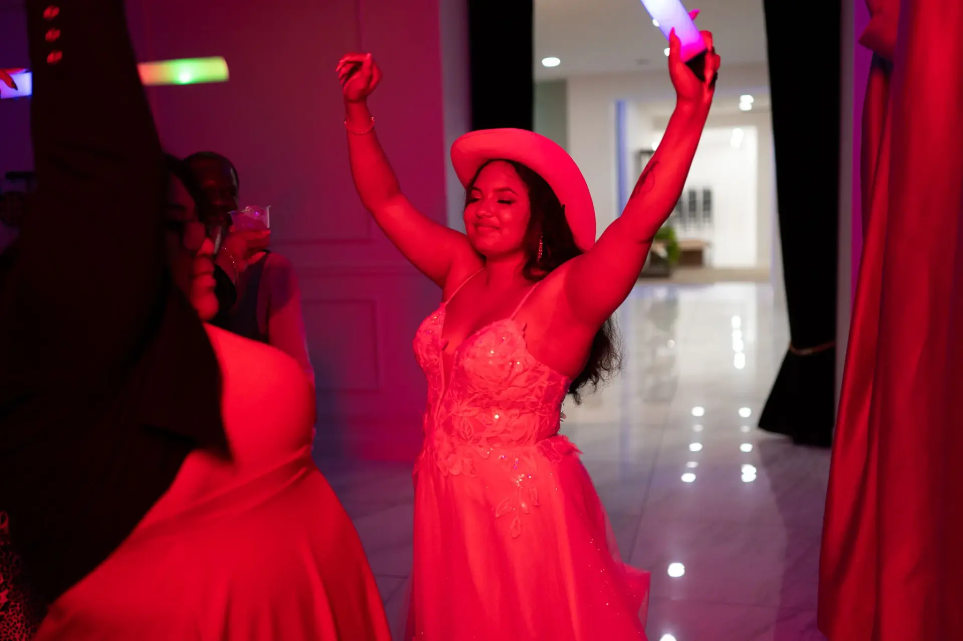 Lauren dancing beneath colorful reception lights