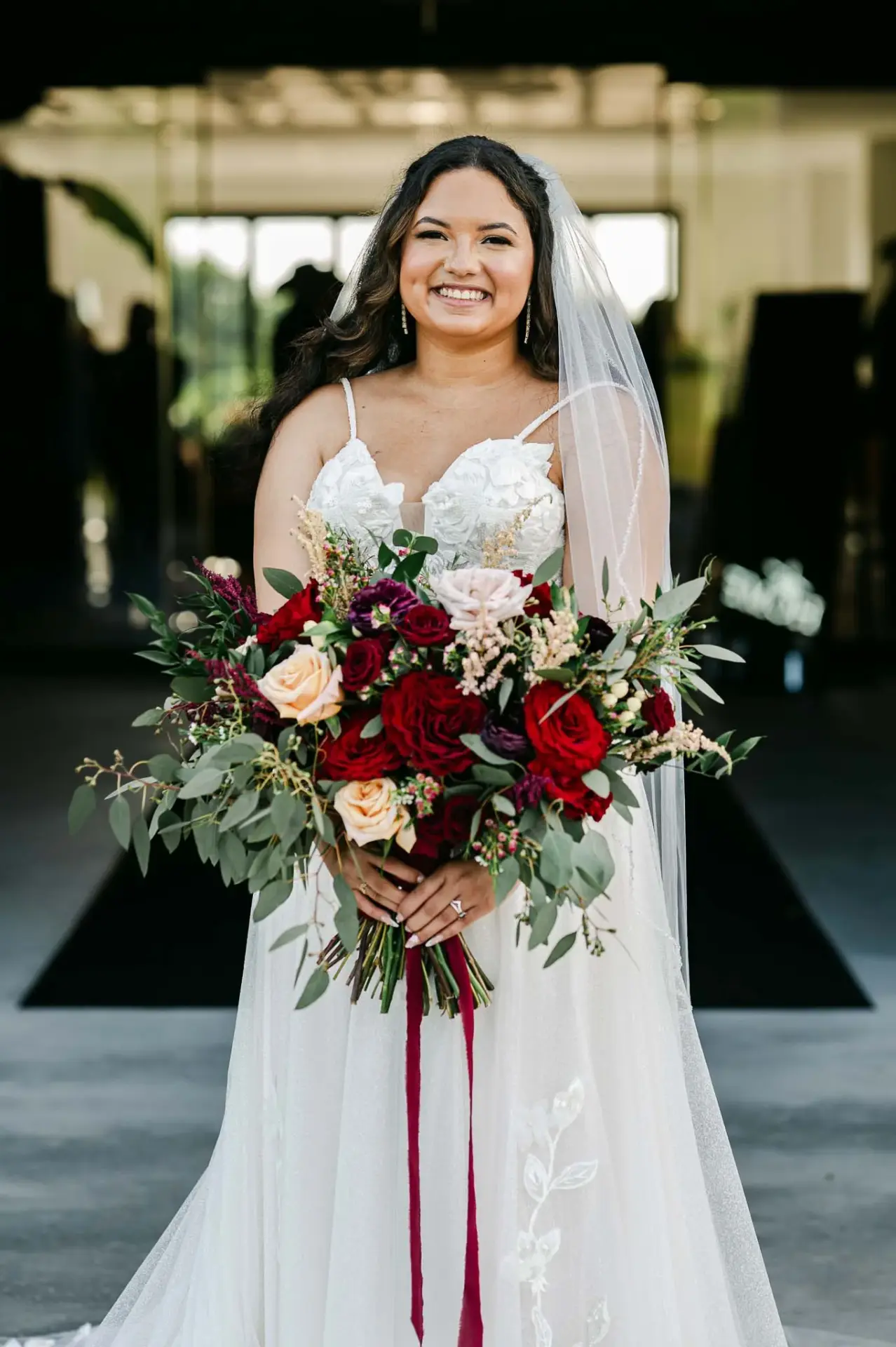 Lauren holding her bouquet in the venue doorway