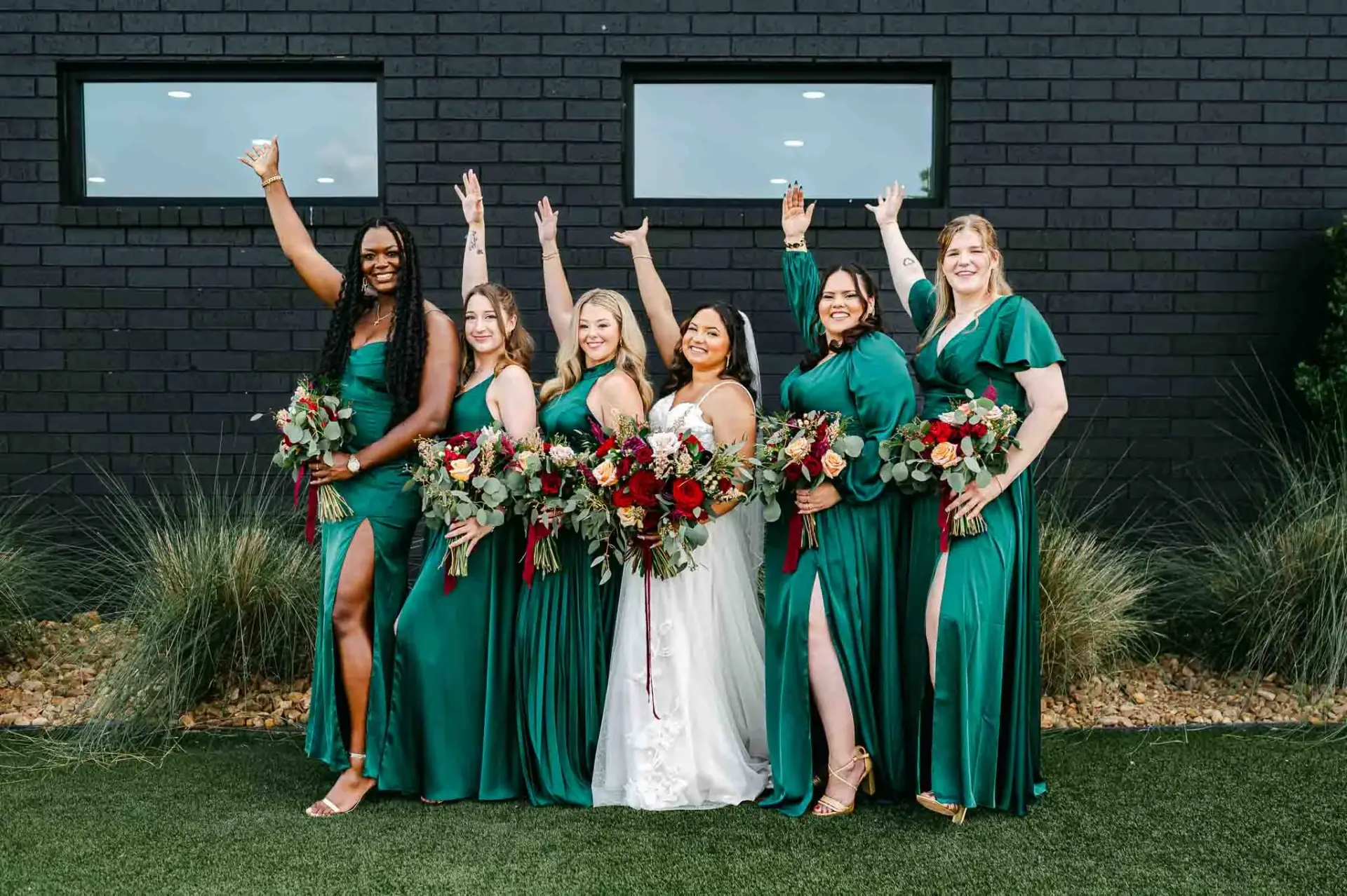 Lauren and her bridesmaids in coordinated green dresses outside the venue