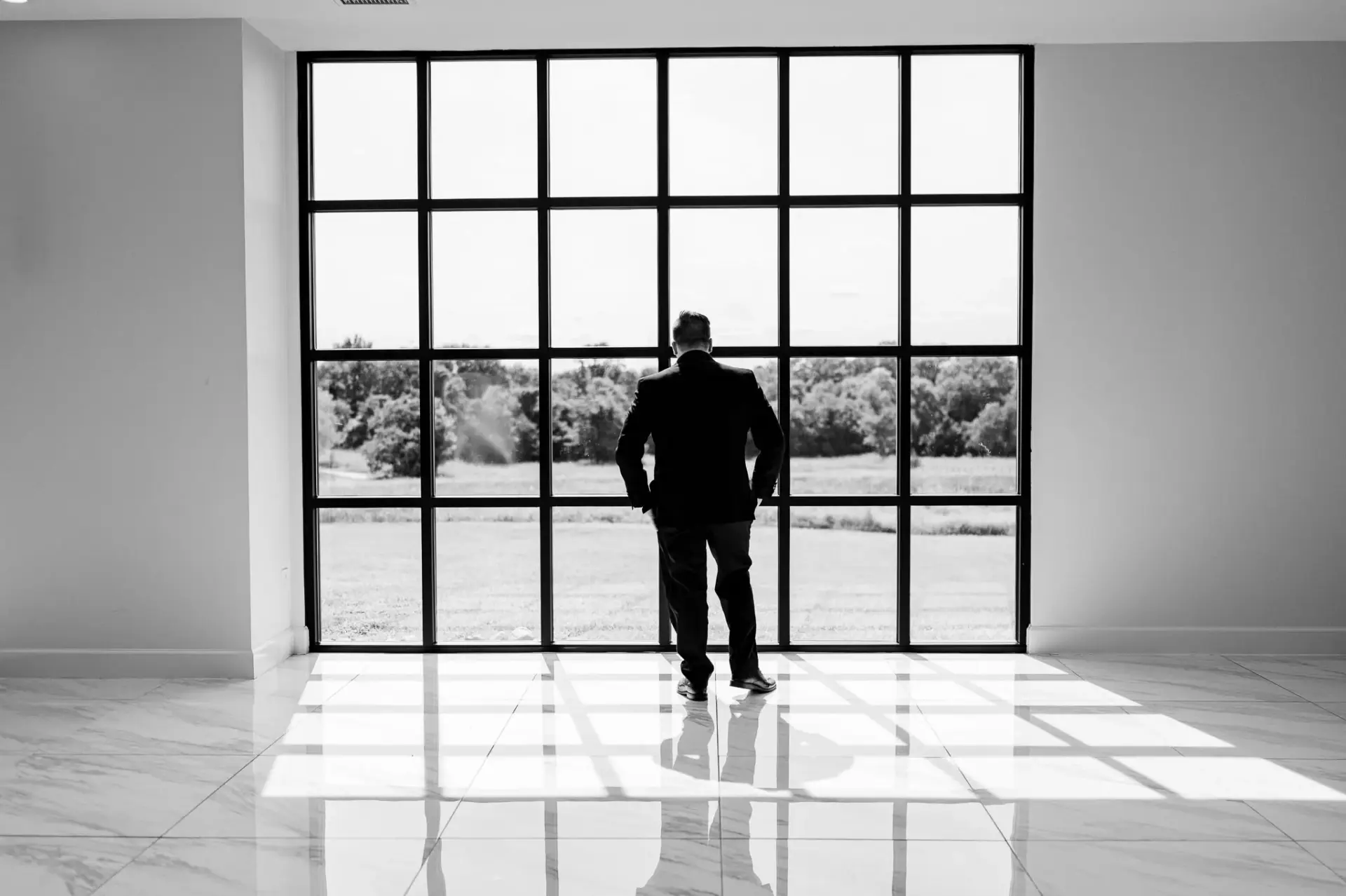 Kyle standing in silhouette at a tall window