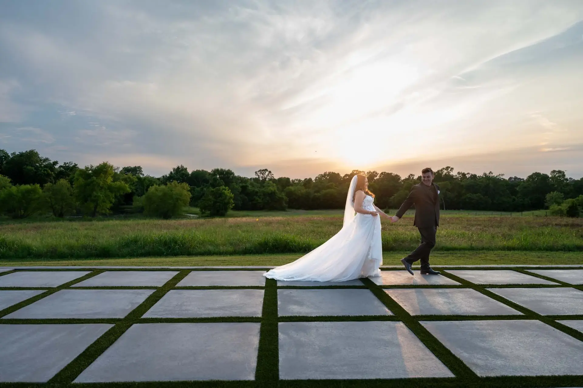 Kyle and Lauren walking together across the venue’s geometric outdoor floor at dusk