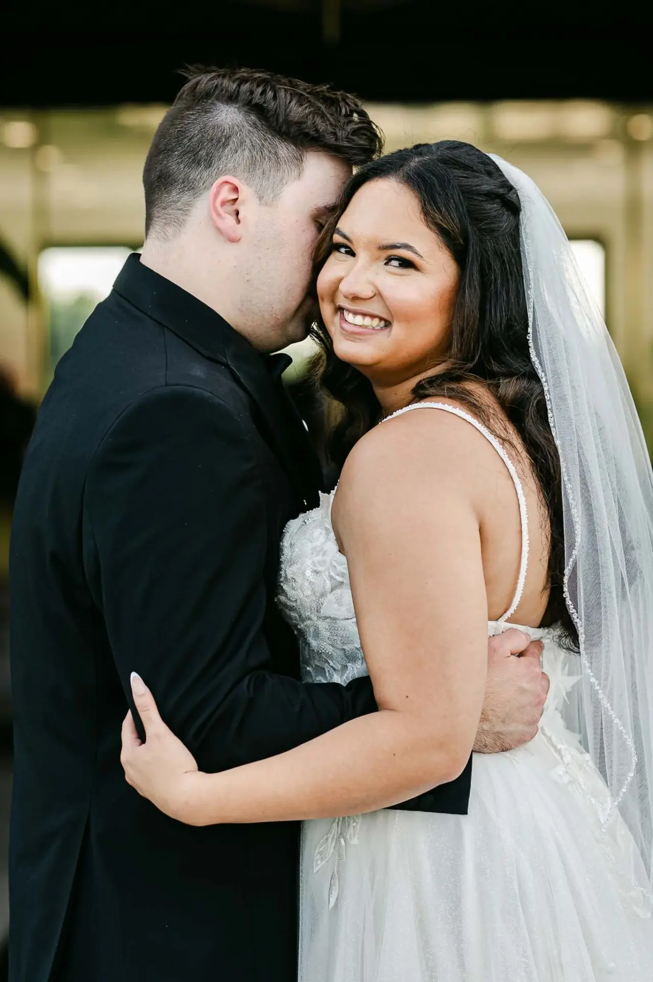 Lauren smiling as Kyle leans close during a quiet portrait