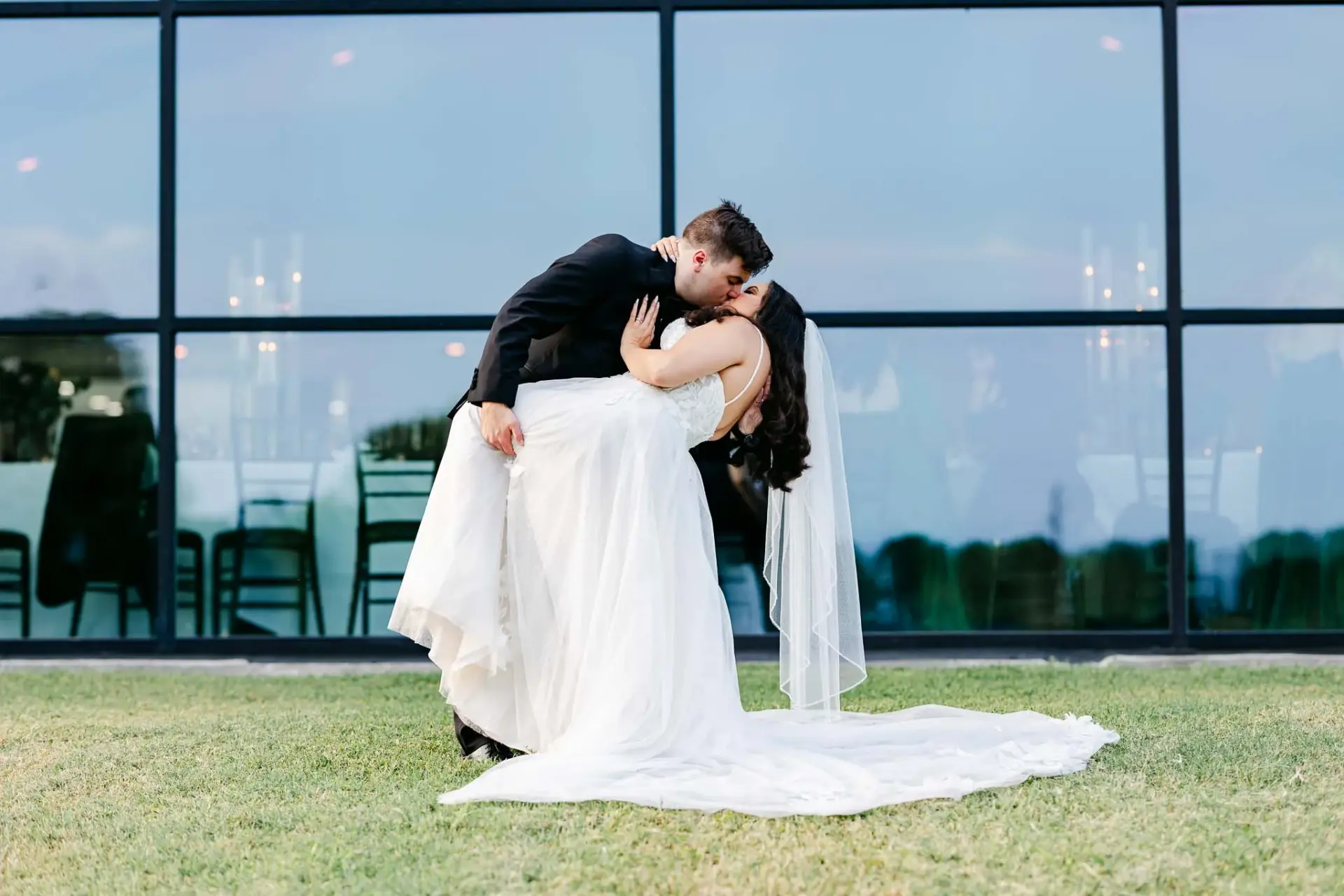 Kyle and Lauren embracing outside the glass-fronted reception space