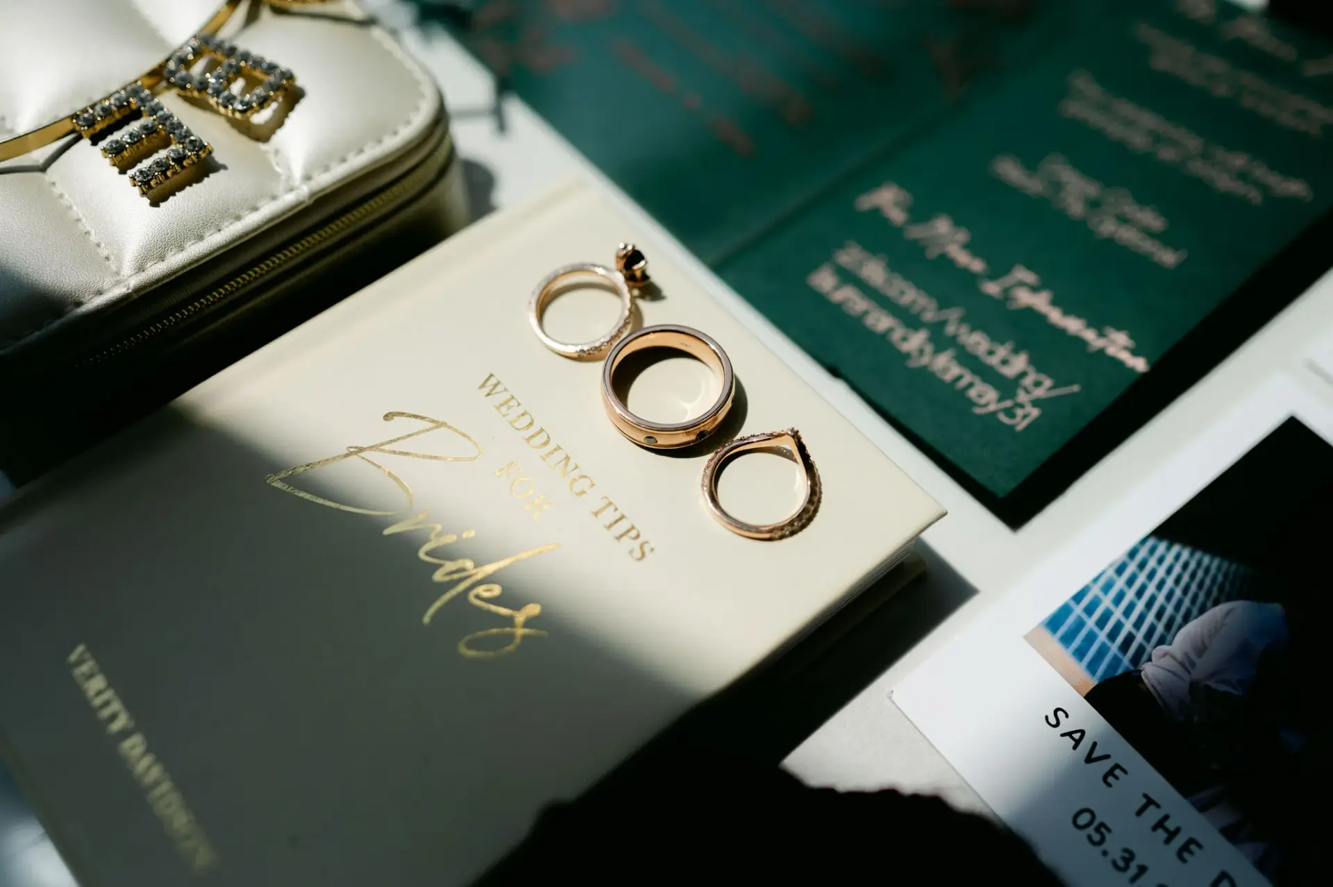 Wedding rings and invitation suite in a shaft of window light
